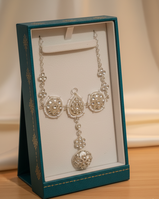 Silver necklace in a decorative box on a wooden surface