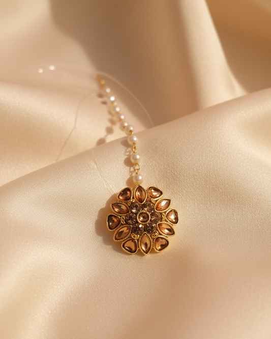 Gold pendant necklace with pearls on a beige satin background